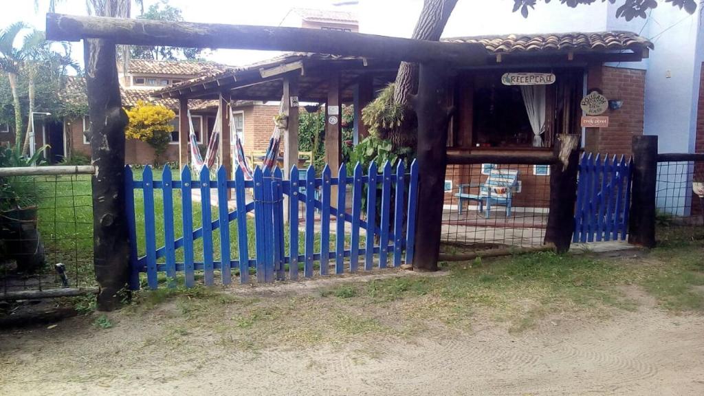 a blue fence in front of a house at Pousada Ponta de Areia do Bixão in Itaúnas