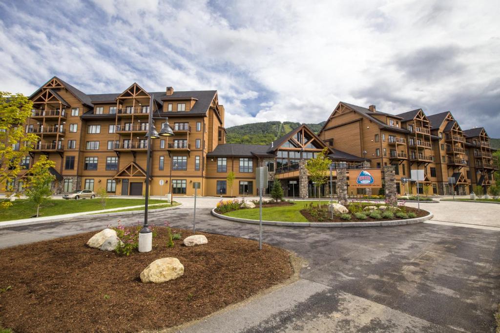 a large apartment building with a parking lot at Burke Mountain Hotel in East Burke