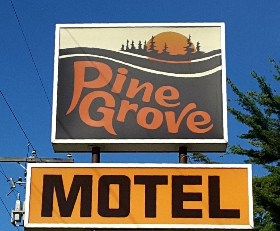 a sign for a pine grove motel on a pole at Pine Grove Motel in Sault Ste. Marie