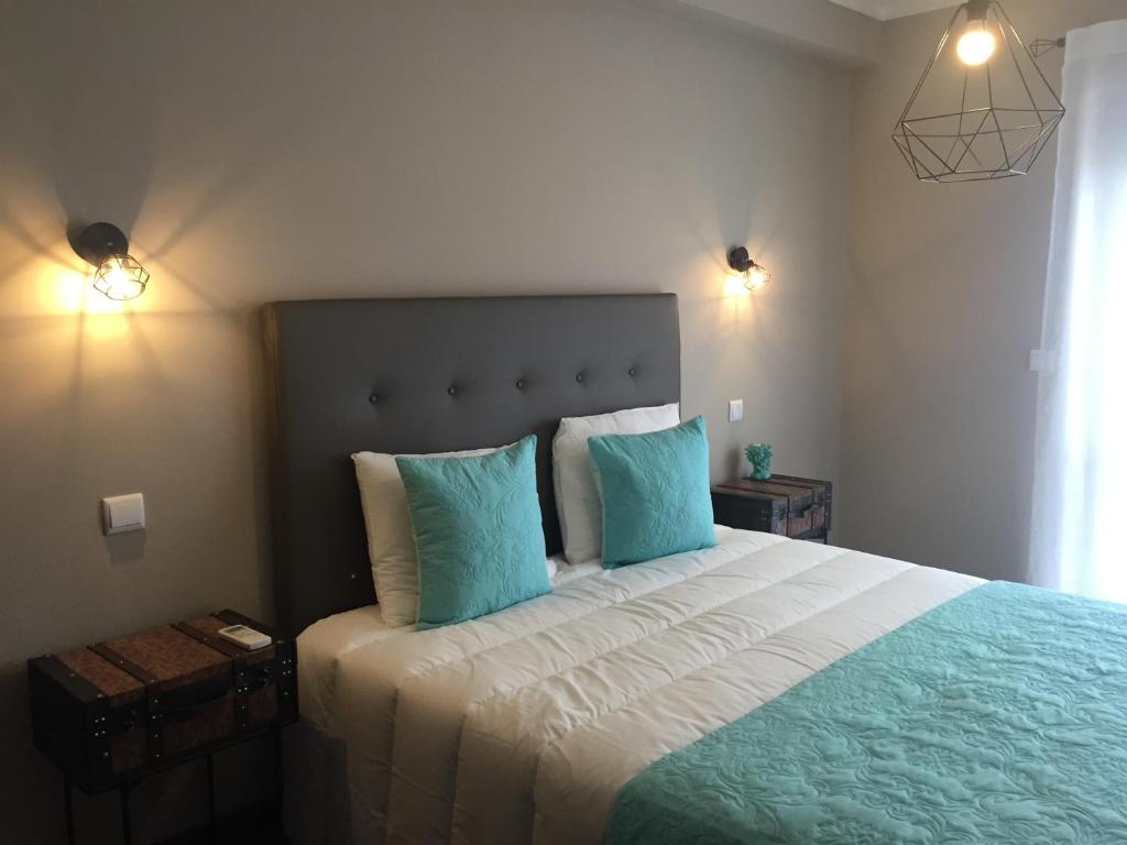 1 dormitorio con 1 cama grande y 2 almohadas azules en The Lighthouse Apartment, en Praia da Barra