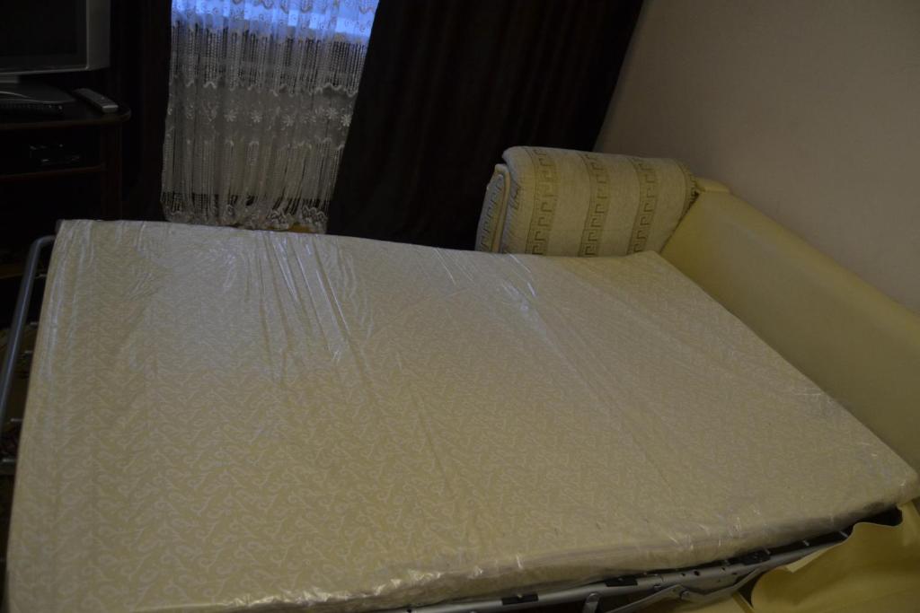 ナリチクにあるApartments on Prospect Leninaのマットレススコーバー付きの客室のベッド1台分です。