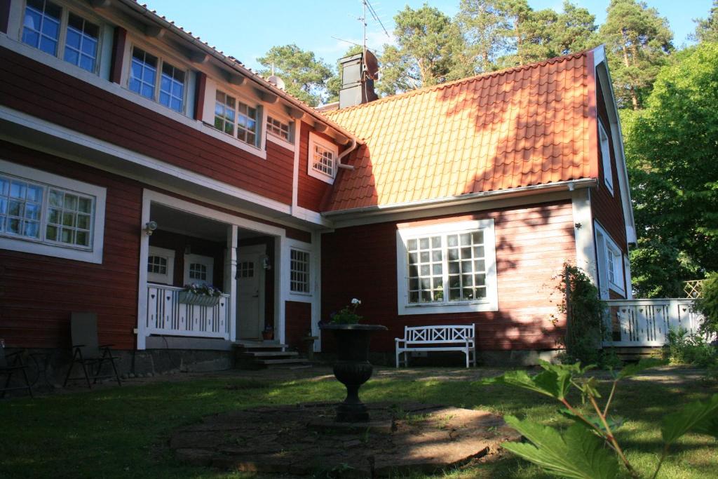 a red house with a bench in front of it at Villa Gräsdalen in Karlstad