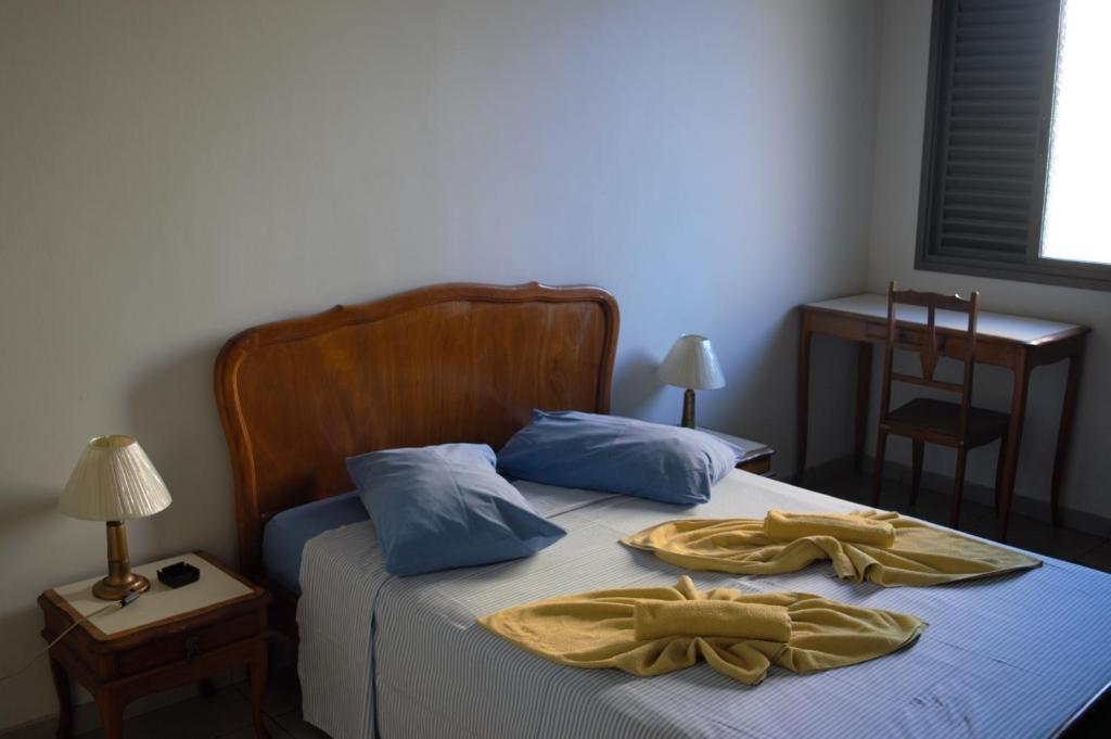 a bedroom with a bed with two towels on it at Hotel Sorrento in Belo Horizonte