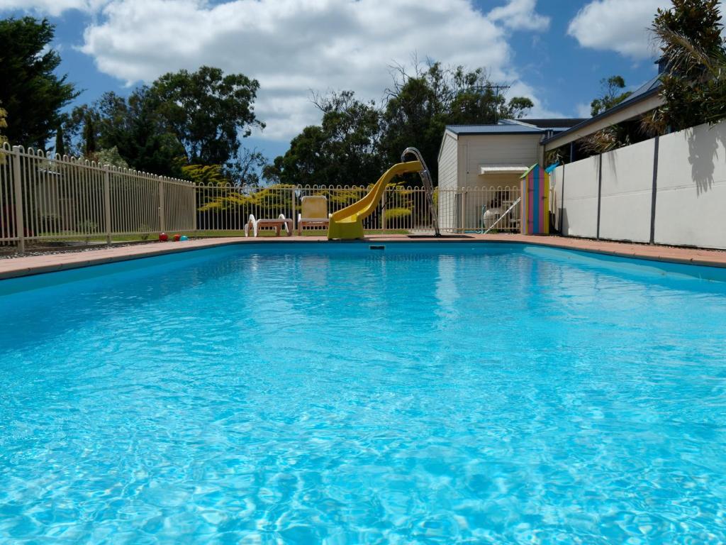 a swimming pool with a slide and a playground at Woodbyne Resort in Cowes