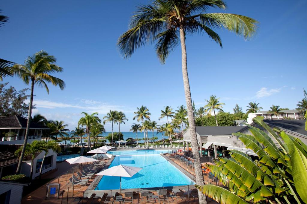 una vista aérea de la piscina del complejo y de las palmeras en Mahogany Hotel Residence & Spa, en Le Gosier