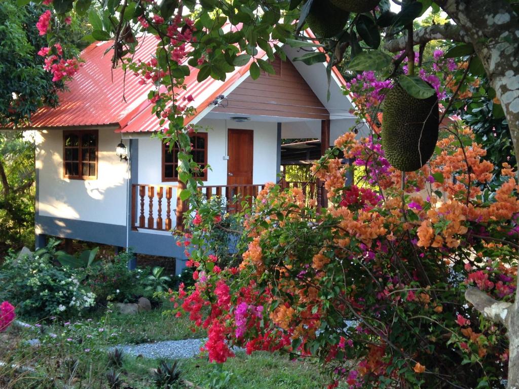 uma casa com um ramo de flores à frente dela em Areeya Resort em Watthana Nakhon