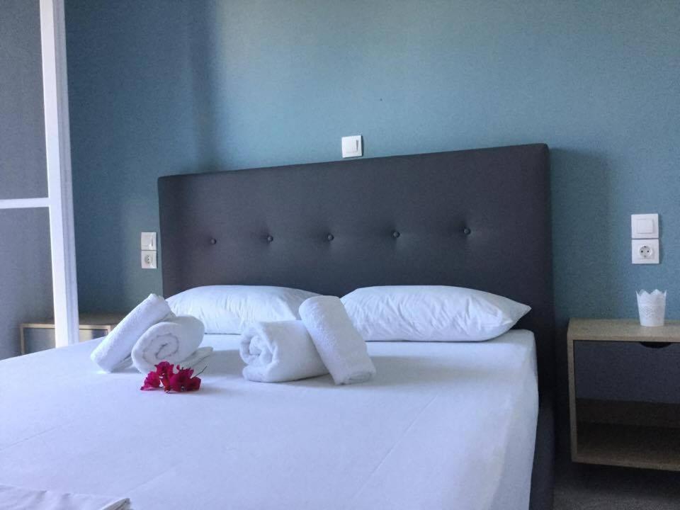 a bed with white pillows and towels on it at Sea Sound in Vasiliki