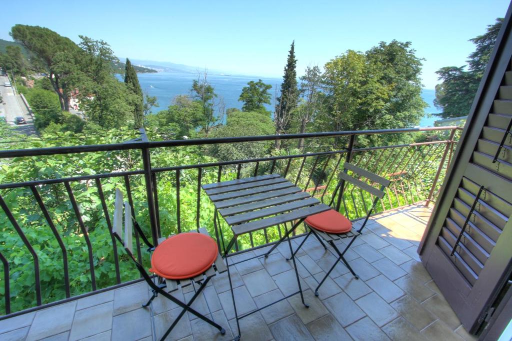 een tafel en stoelen op een balkon met uitzicht bij Apartman Lena in Opatija