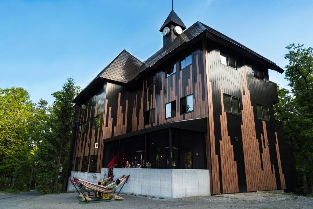 a large wooden building with a clock tower on top at Hotel Villa Hakuba in Hakuba