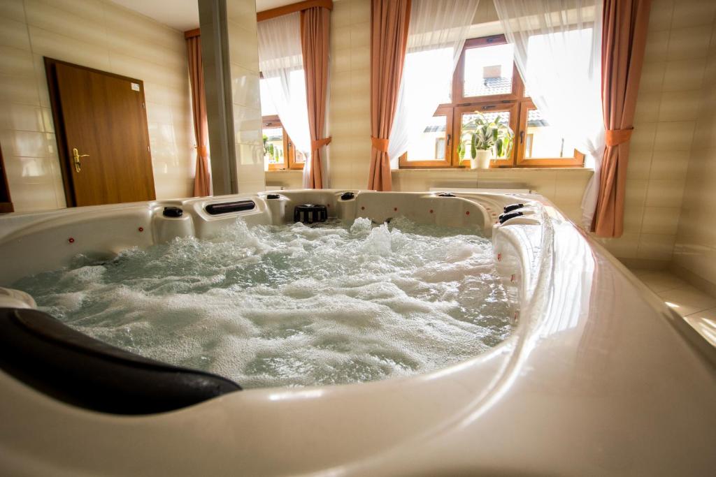 a bath tub filled with water in a room at Hotel Chańcza in Raków