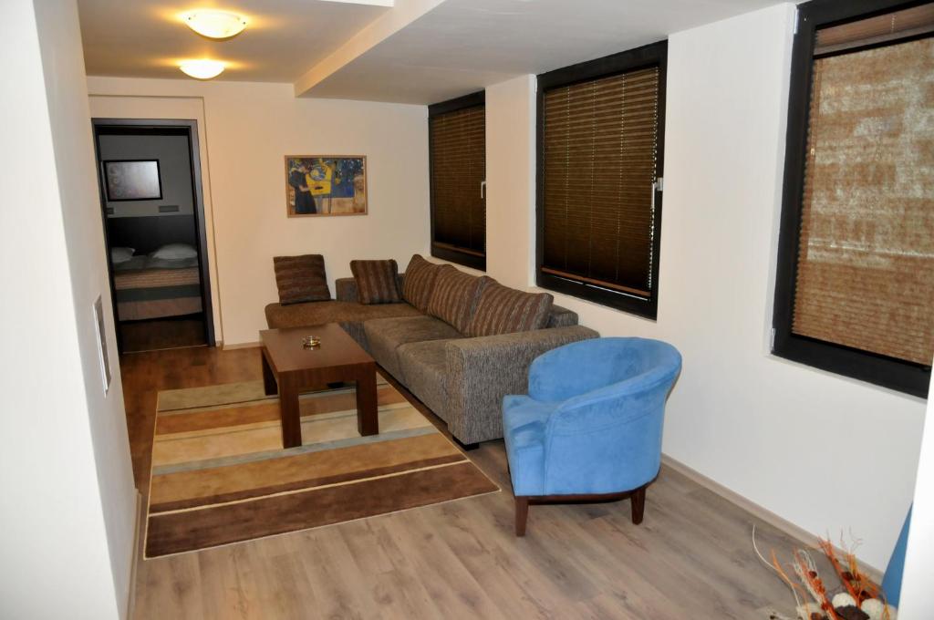 a living room with a couch and a blue chair at Hotel Burgas Free University in Burgas