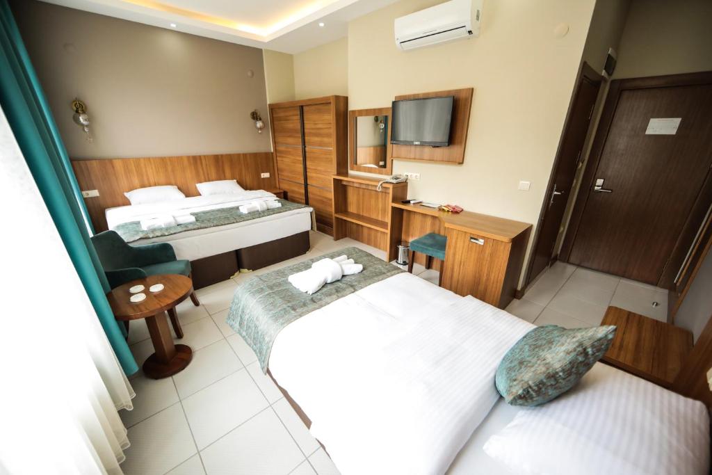 FatsaにあるFatsa Safi̇r Otelのベッド2台とテレビが備わるホテルルームです。