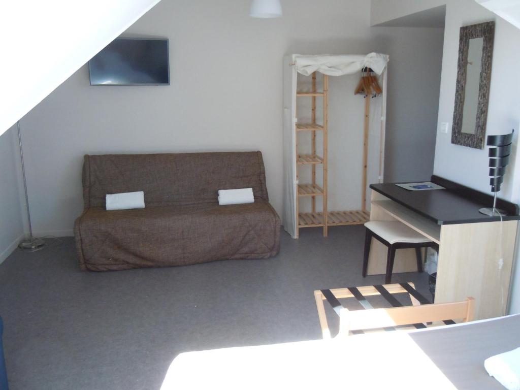 a living room with a couch and a table at Sweet Home Appart'Hôtel Deauville Sud in Deauville