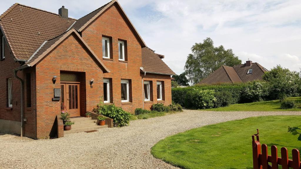 a brick house with a gravel driveway at Ferienwohnung Stadie in Dörphof