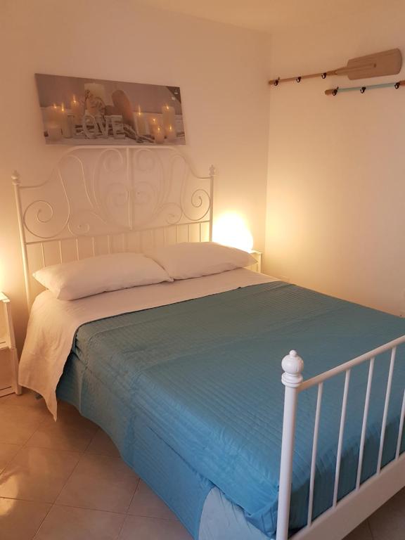 a bedroom with a white bed with a blue blanket at Casa Vacanza La Conchiglia in Monopoli