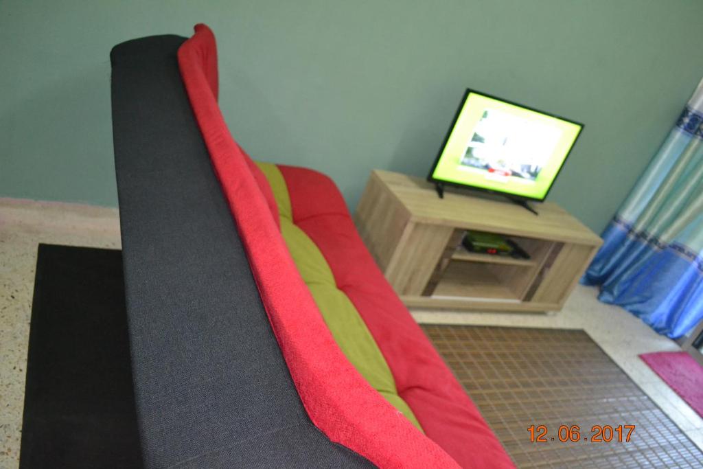 una coperta rossa e gialla sul pavimento di fronte a una televisione di Teknologi Kajang Homestay a Kajang