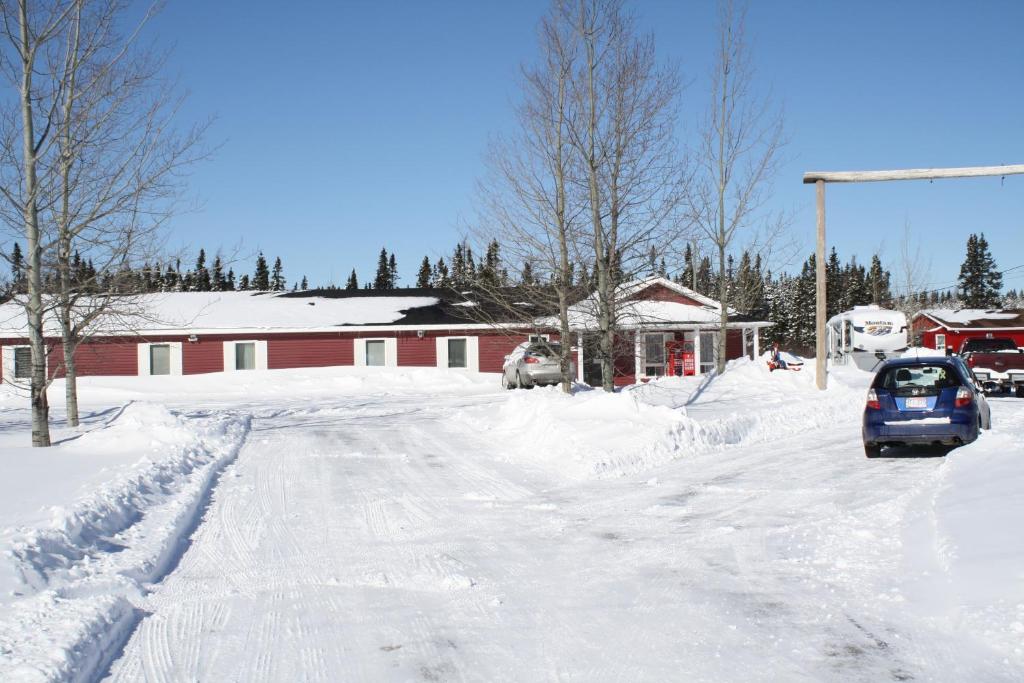 un coche está conduciendo por una calle cubierta de nieve en The Country Inn Motel en Gander