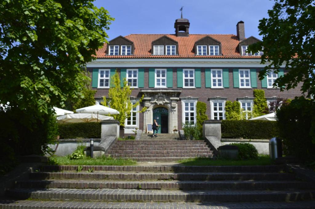 a large building with stairs in front of it at Bio- und Gesundheitshotel Gutshaus Stellshagen in Stellshagen