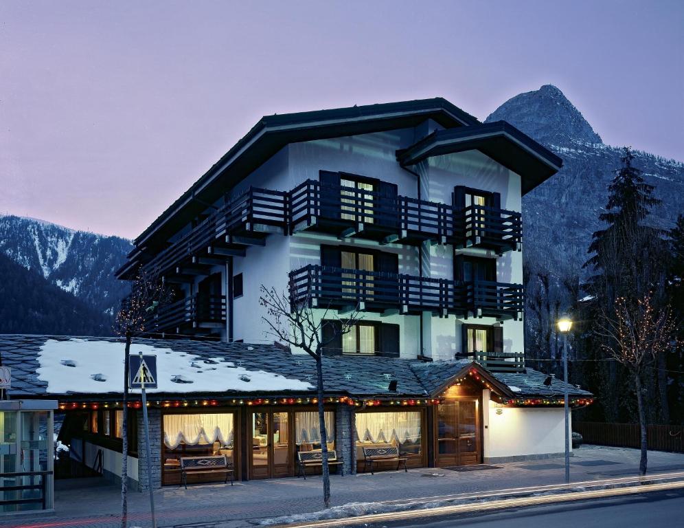 budynek w górach ze śniegiem w obiekcie Hotel Les Jumeaux Courmayeur w mieście Courmayeur