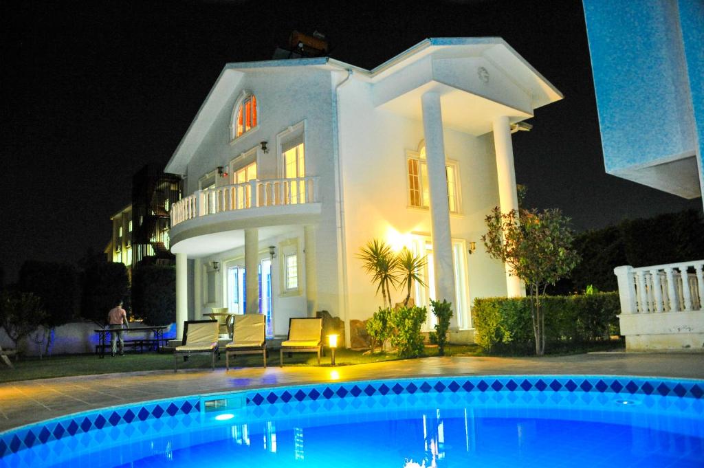 una gran casa blanca por la noche con piscina en Penelope Villa, en Belek