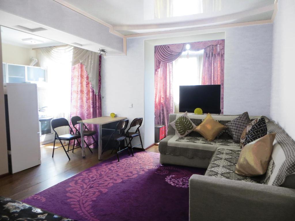 sala de estar con sofá y mesa en Best-Bishkek City Apartment, en Bishkek