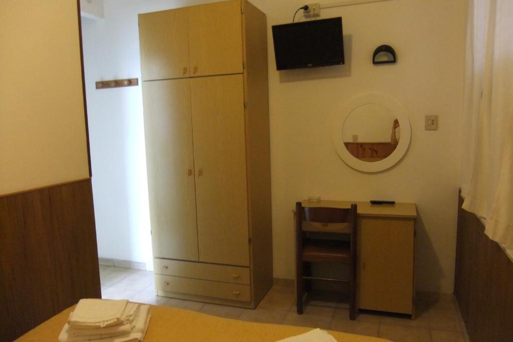 リミニにあるAlbergo Villalmaのベッドルーム(キャビネット、鏡付きテーブル付)
