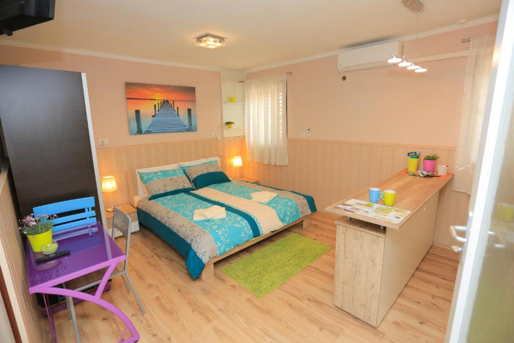 a small bedroom with a bed and a table at Apartment Centar in Pula