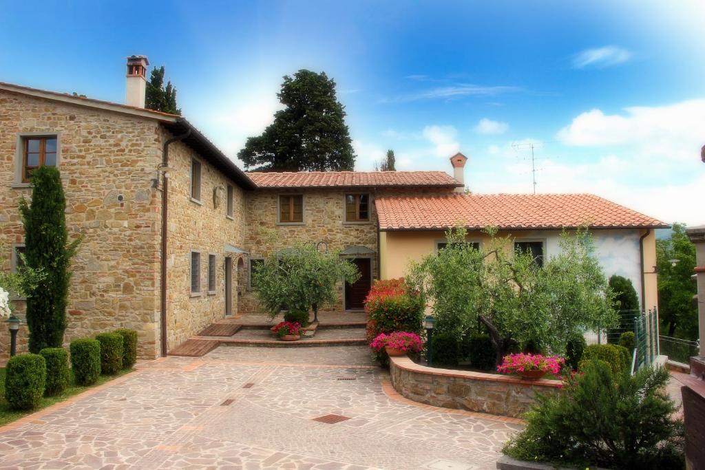 kamienny dom z dziedzińcem przed nim w obiekcie Residence il Poggiolino w mieście Montecarelli