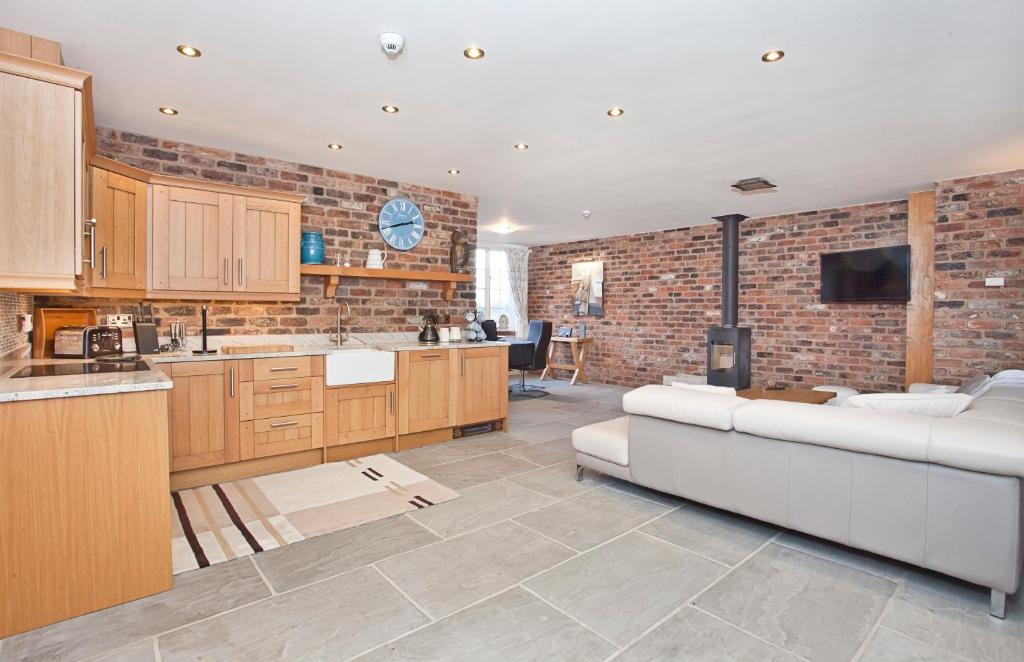 a living room with a white couch and a brick wall at Holtby Grange Cottages in York