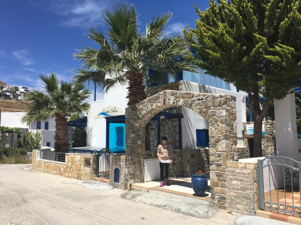 a woman standing in front of a house at Serifos Palace in Livadakia