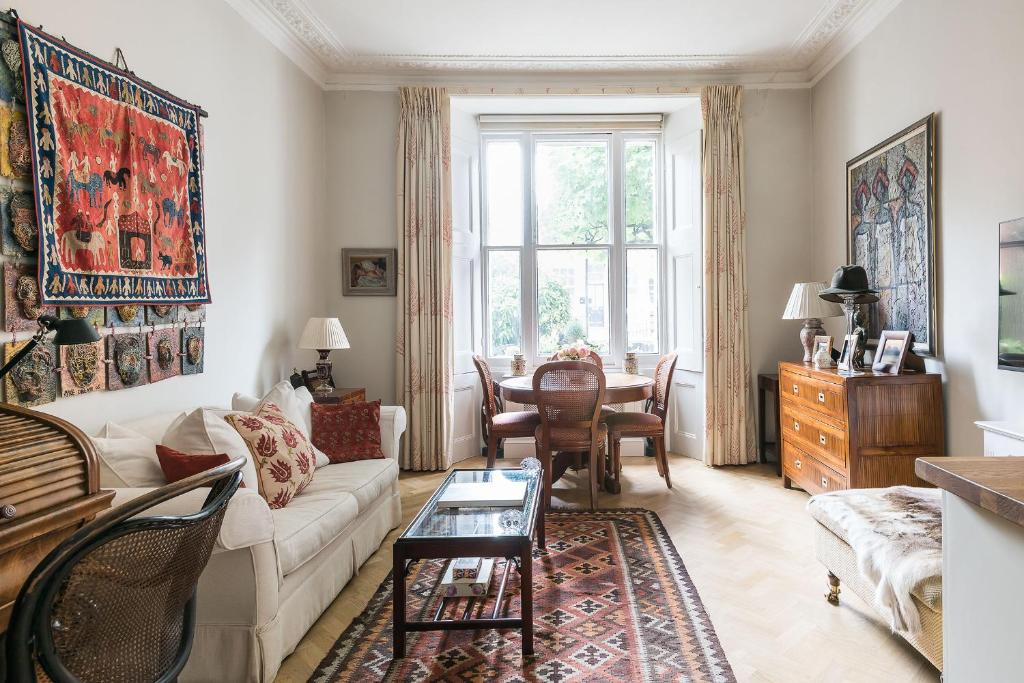 uma sala de estar com um sofá e uma mesa em The Hummingbird - Stylish 1-Bed by Kensington Gardens em Londres