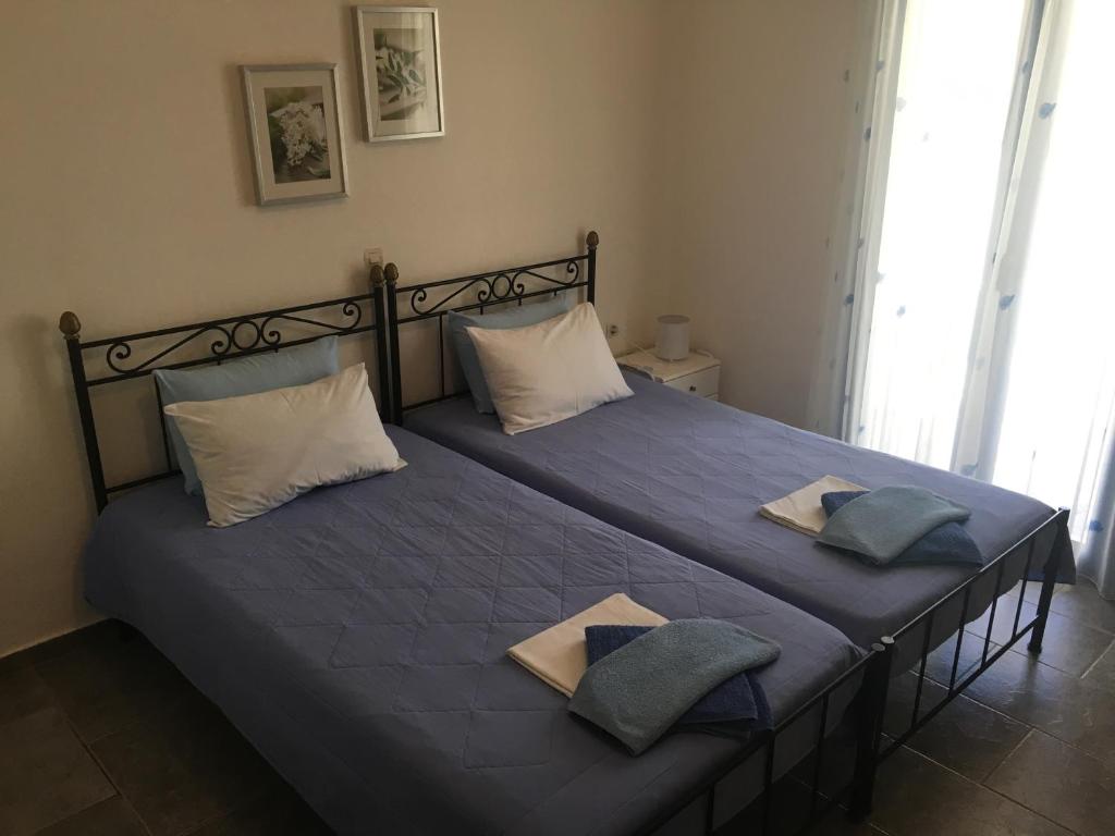 a bedroom with a bed with blue sheets and pillows at Serifos Palace in Livadakia