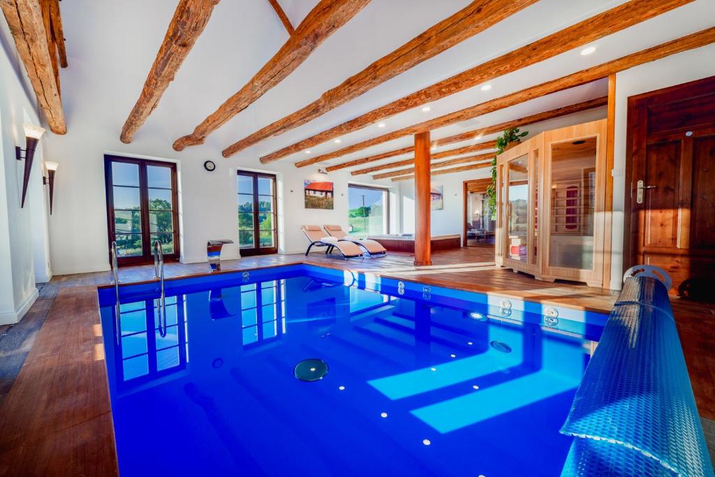 an indoor pool with blue water in a house at Willa SPAcja in Wężówka