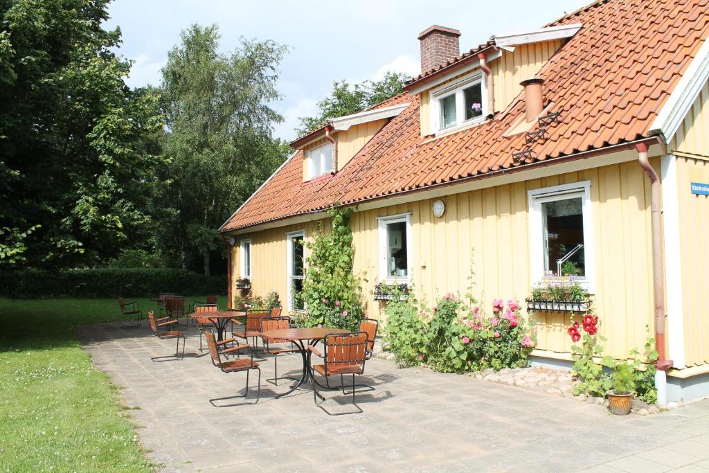 a patio with tables and chairs next to a house at Nyckelbo Vandrarhem in Helsingborg