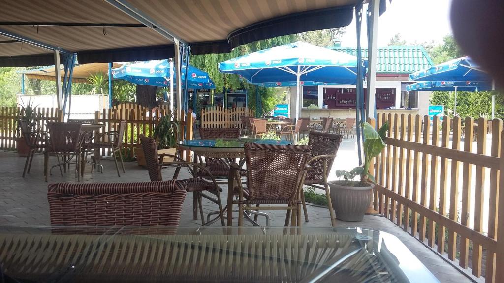 an outdoor patio with tables and chairs and umbrellas at Shushan GUEST HOUSE in Yeghegnadzor