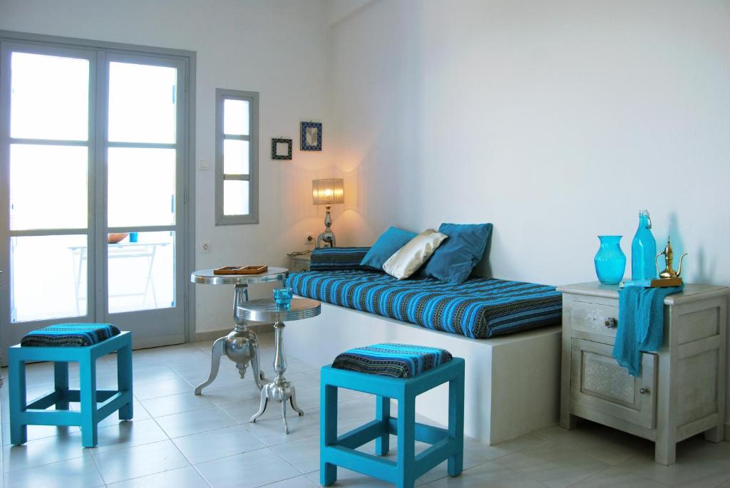 sypialnia z łóżkiem i 2 niebieskimi stołkami w obiekcie Milatos Village Cretan Agrotourism Hotel w mieście Milatos