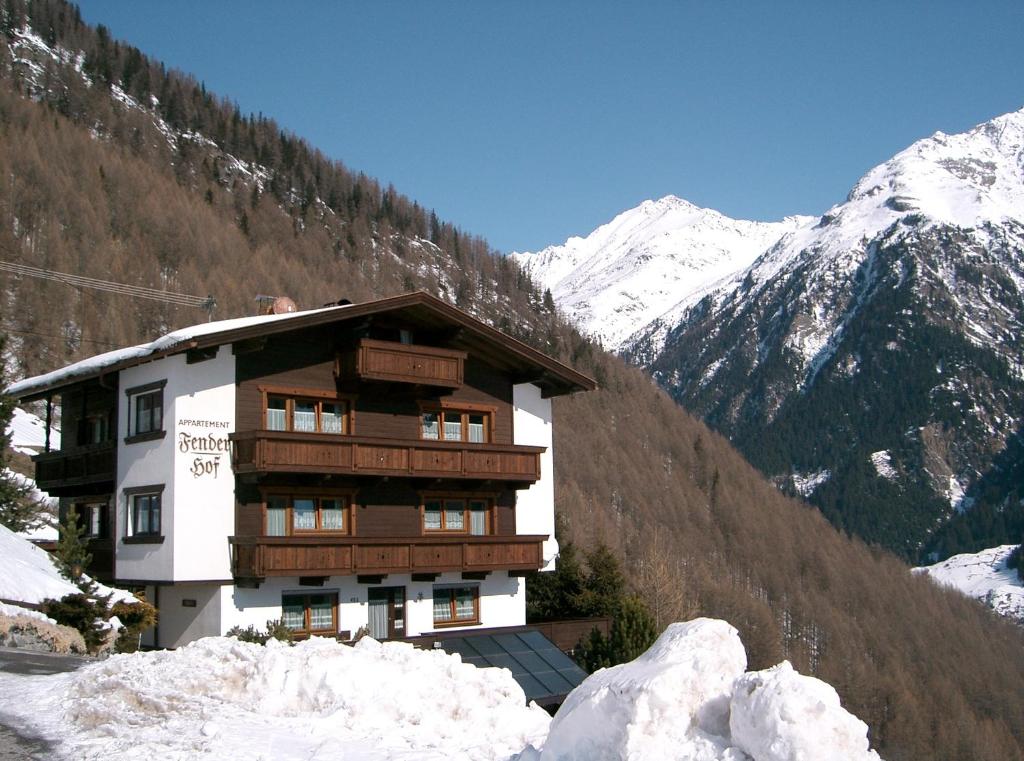 un bâtiment dans les montagnes avec de la neige au sol dans l'établissement Fenderhof, à Sölden