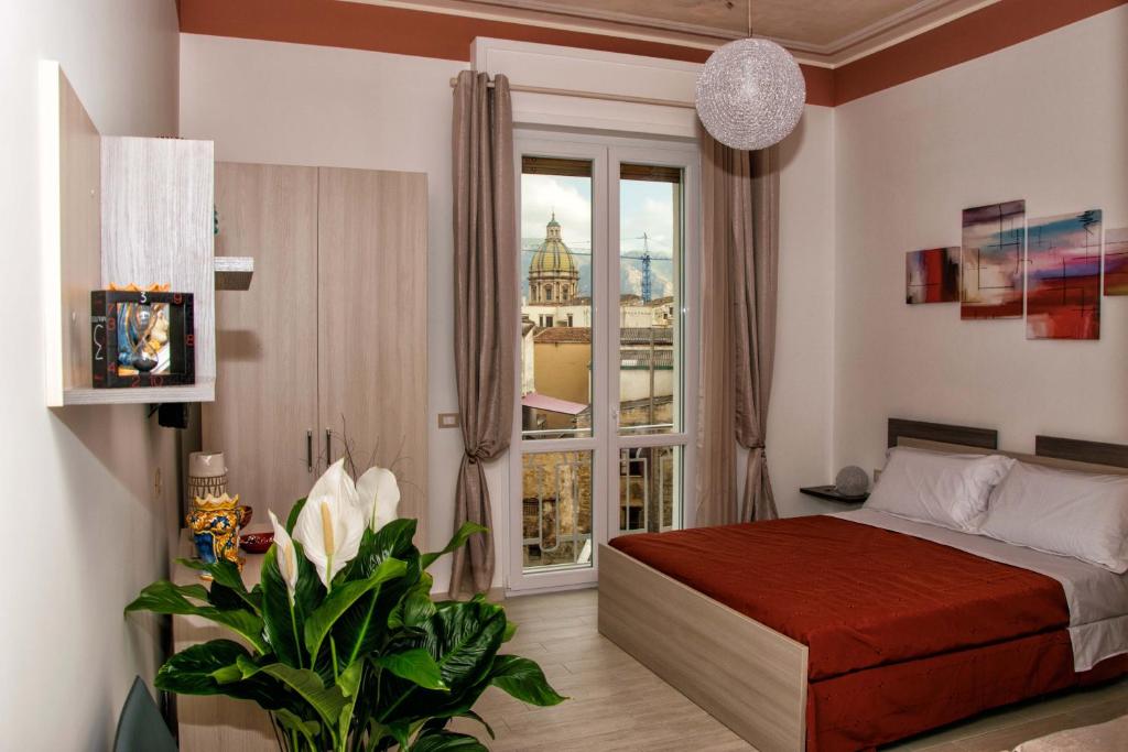 sypialnia z łóżkiem i dużym oknem w obiekcie Le Cupole Decò w mieście Palermo