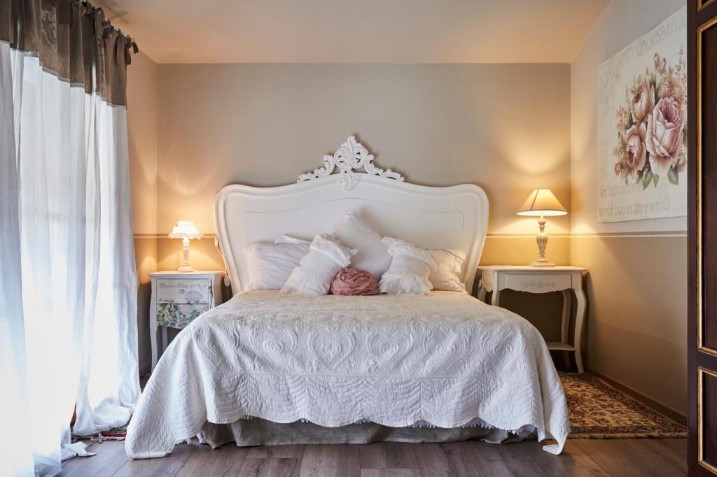 - une chambre dotée d'un lit blanc avec des draps et des oreillers blancs dans l'établissement Ronchettino B&B Rozzano, à Rozzano