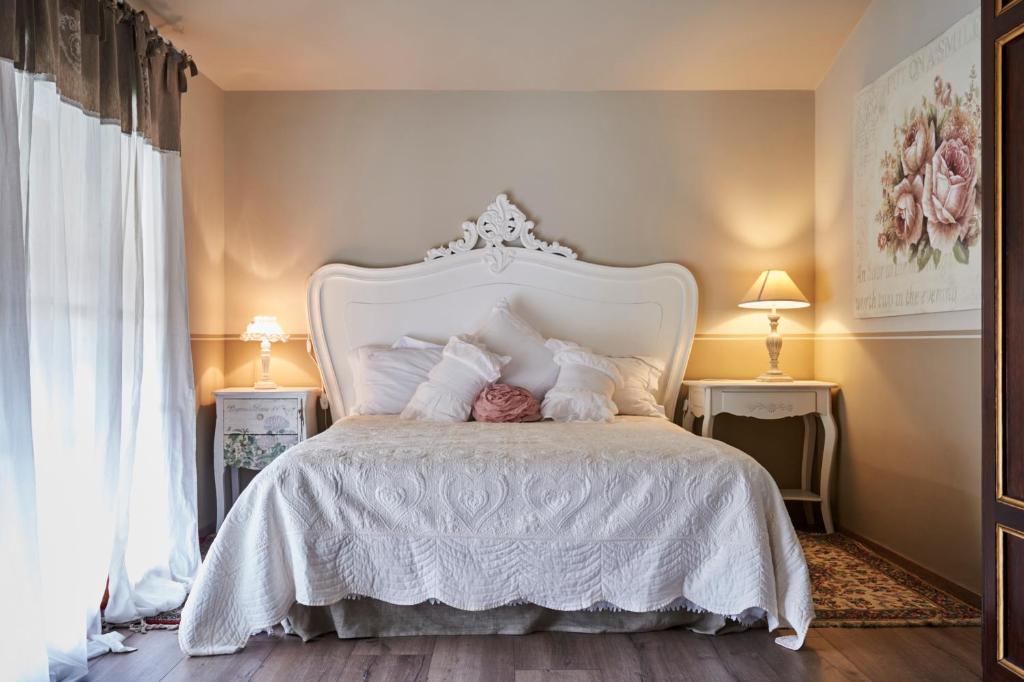 a bedroom with a white bed with white sheets and pillows at CR BnB Rozzano in Rozzano