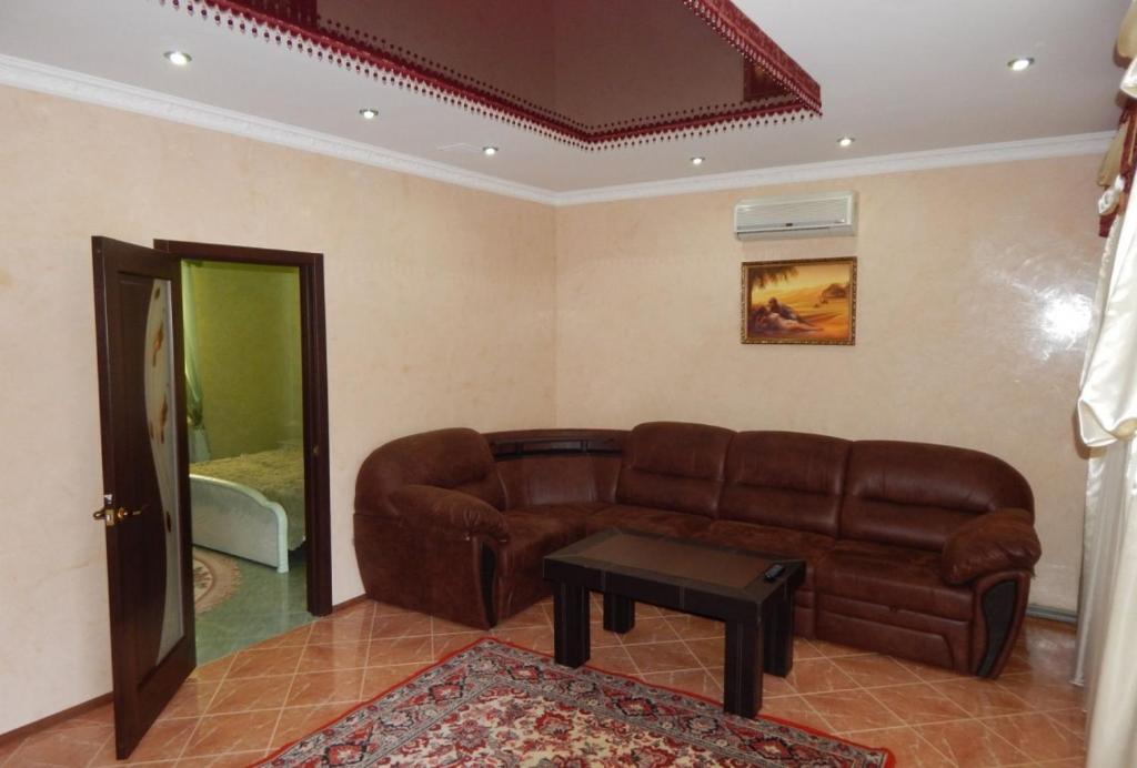 un soggiorno con divano marrone e tavolo di Mini Hotel Business class a Kryvyj Rih
