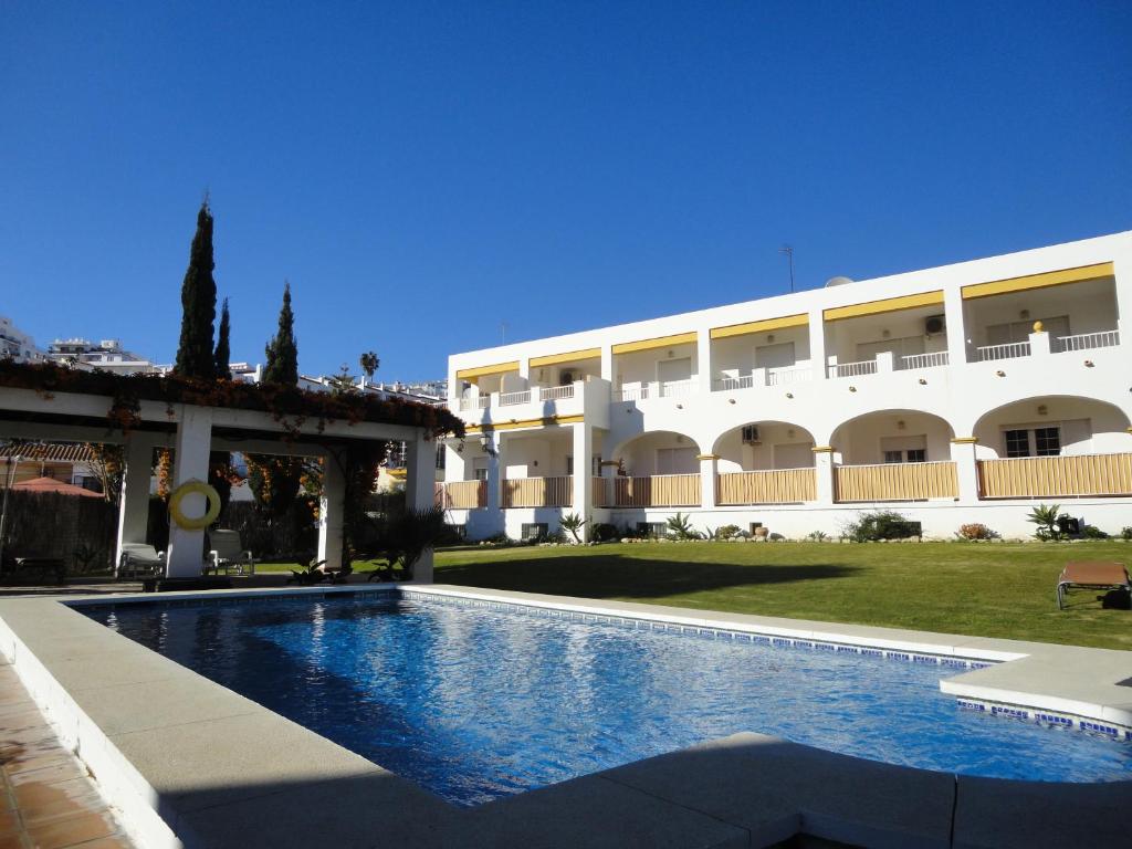 a swimming pool in front of a building at AT Almoraide Rooms Suites in Nerja