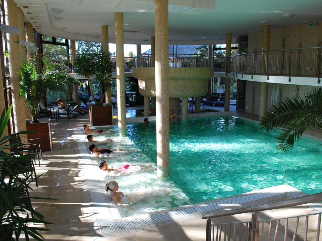 a group of people swimming in a swimming pool at Wellness Hotel Gyula in Gyula