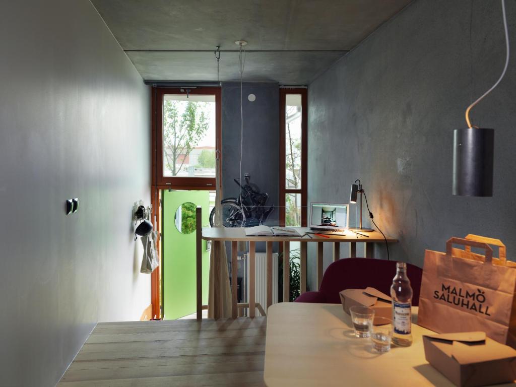 a dining room with a table and a green door at Ohboy Hotell in Malmö