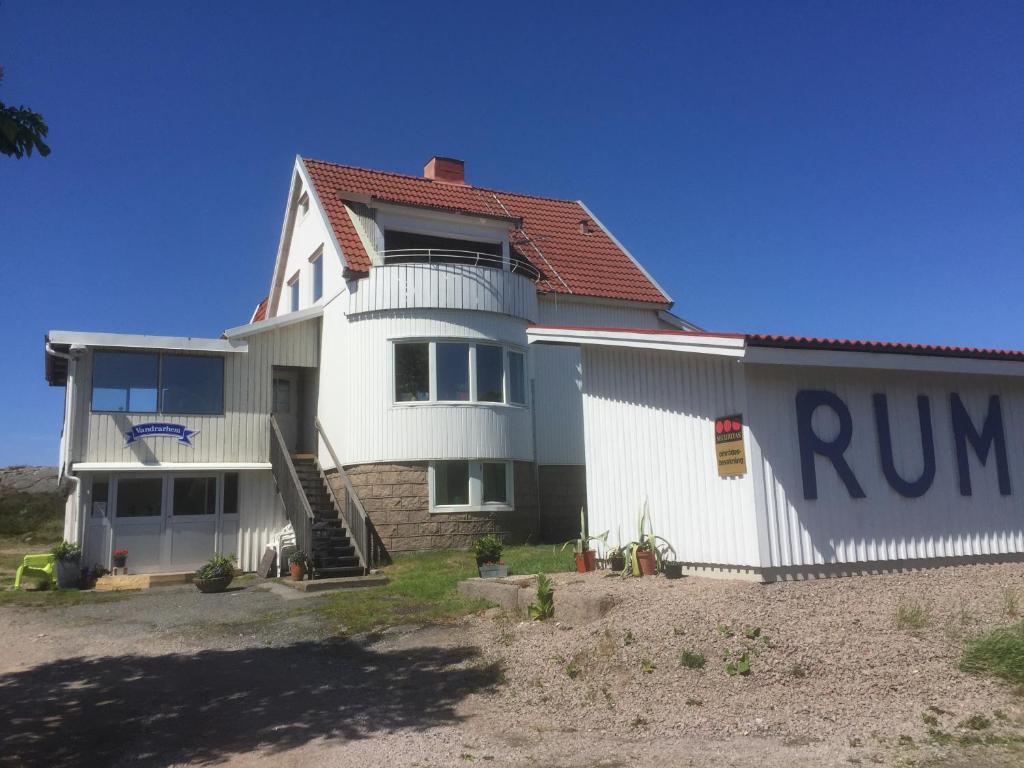 una casa blanca con una señal de correr delante de ella en Kungshamns Vandrarhem en Kungshamn