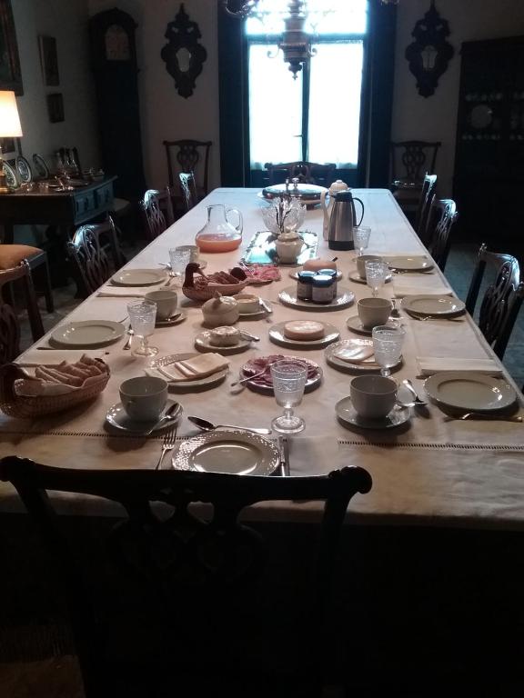 uma mesa longa com pratos e pratos em Solar Olivas Apartments em Carvalhal