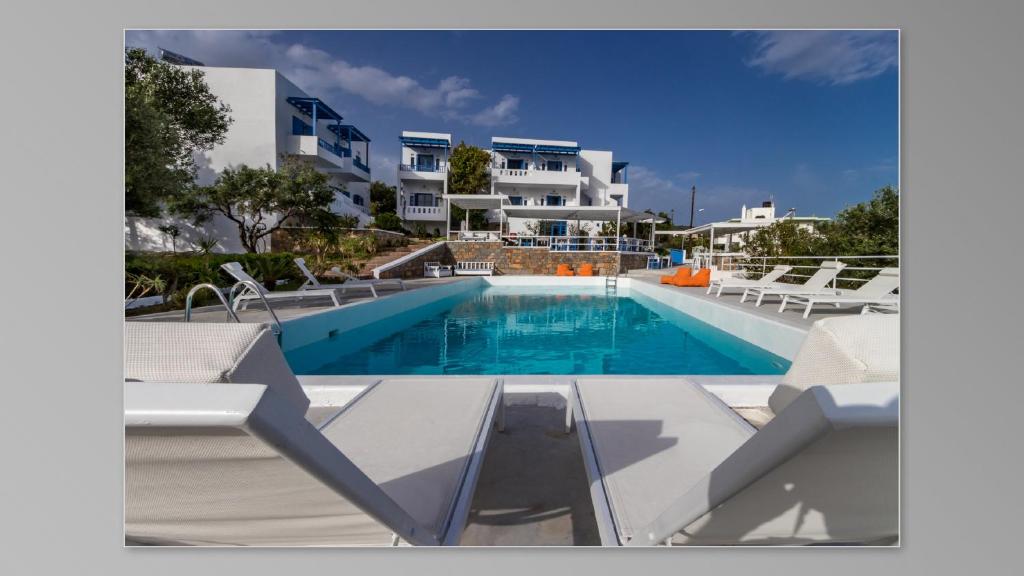 basen z krzesłami przed budynkiem w obiekcie Milatos Village Cretan Agrotourism Hotel w mieście Milatos