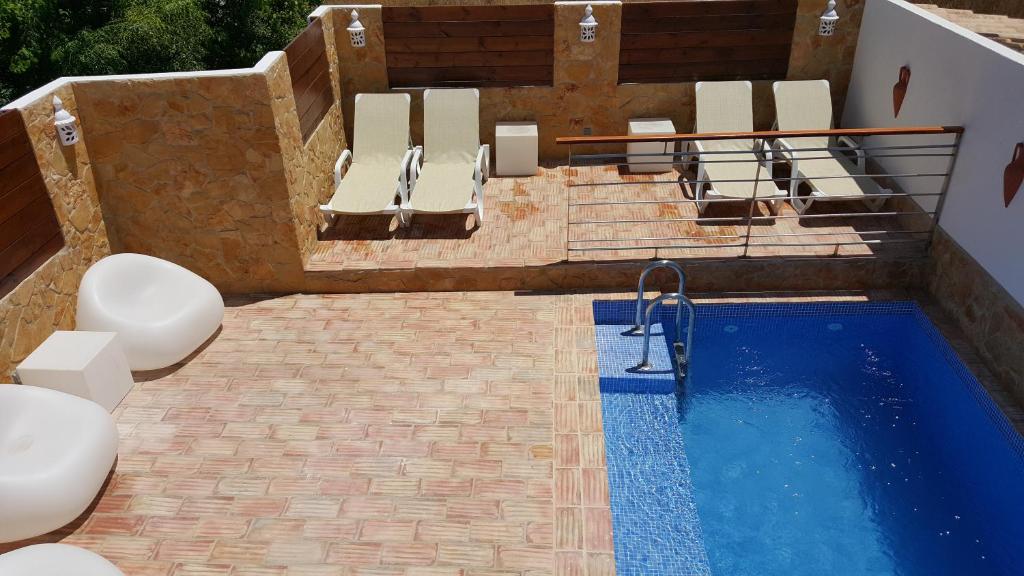 an overhead view of a swimming pool with lounge chairs and a swimming pool at Seaview Guesthouse in Olhão