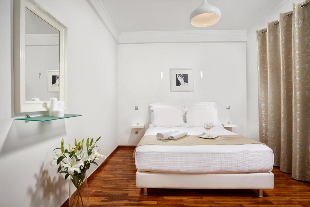 - une chambre blanche avec un lit et une fenêtre dans l'établissement Modern and Cozy Apartment in the centre of Athens, à Athènes