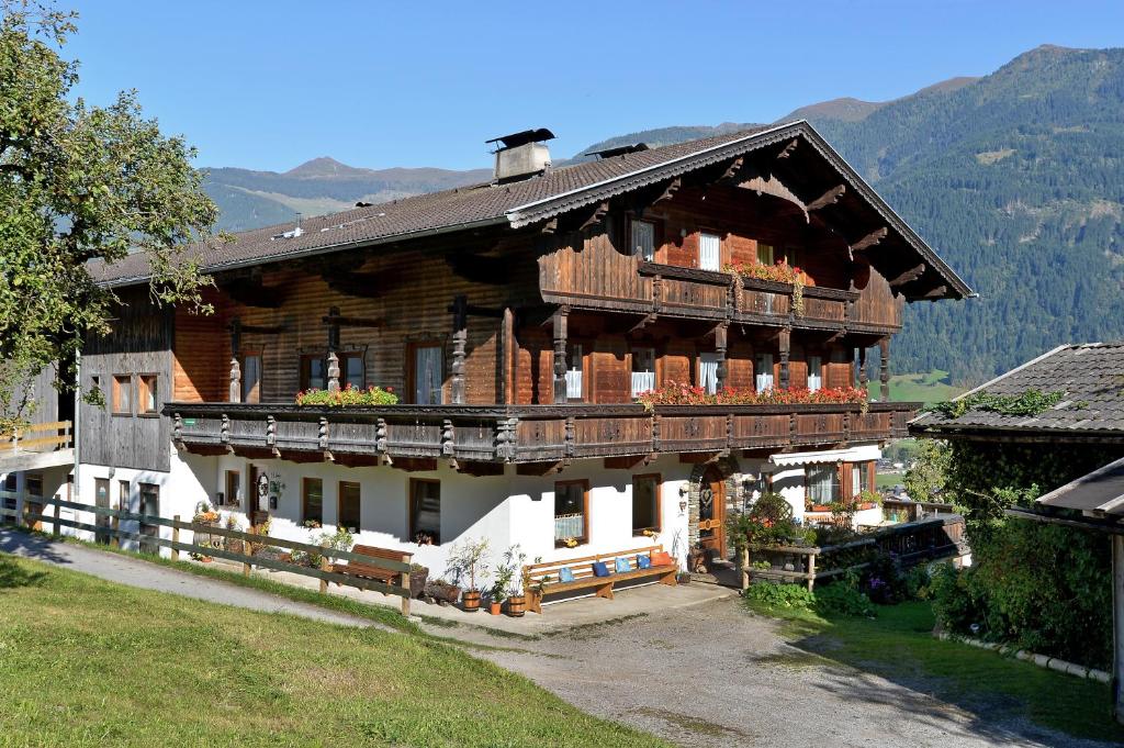 a large wooden house with a balcony on top at Wermenerhof in Fügenberg